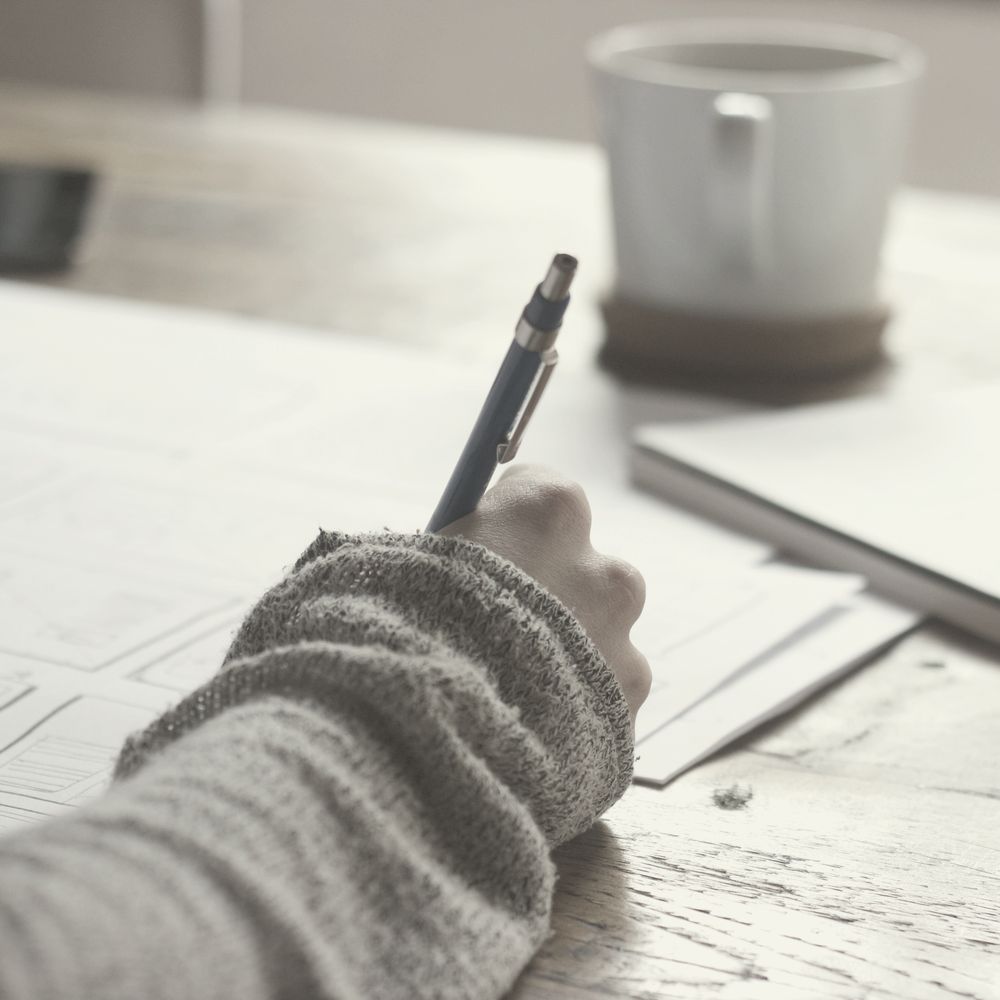A hand with a pen working on a document